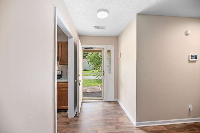 entryway with hardwood / wood-style floors and a textured ceiling