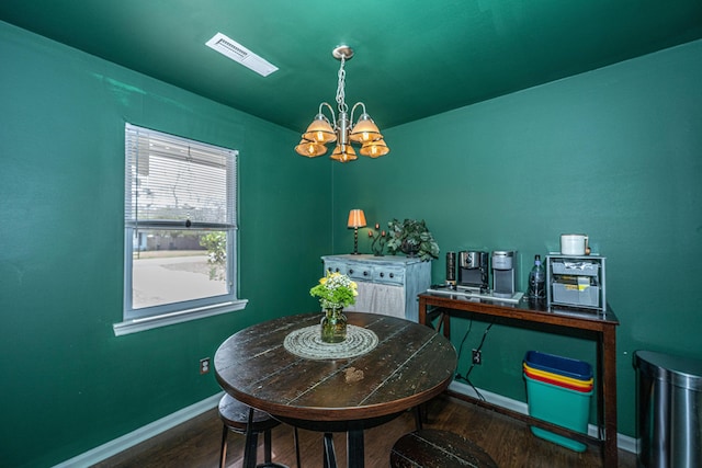 dining area with baseboards, visible vents, a chandelier, and wood finished floors