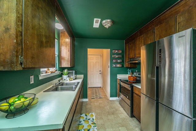 kitchen featuring visible vents, appliances with stainless steel finishes, light countertops, under cabinet range hood, and a sink