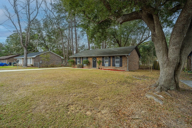 single story home featuring a front yard and brick siding