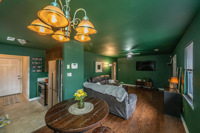 living area with wood finished floors, a ceiling fan, and baseboards