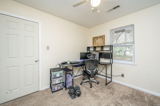 carpeted office space featuring baseboards, visible vents, and a ceiling fan