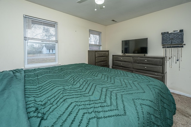 carpeted bedroom with ceiling fan and visible vents