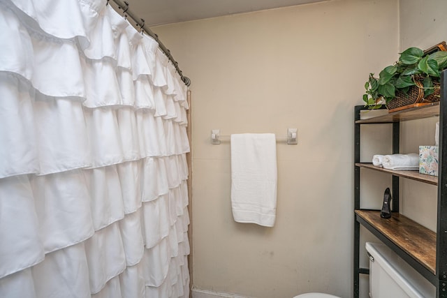 bathroom featuring a shower with shower curtain and toilet