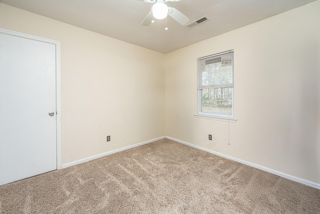 carpeted empty room featuring baseboards, visible vents, and a ceiling fan