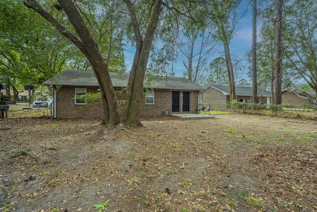 back of house with fence and brick siding