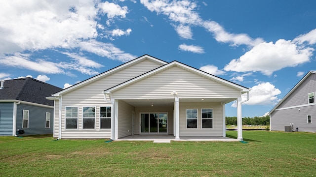 rear view of property with cooling unit, a patio area, and a yard