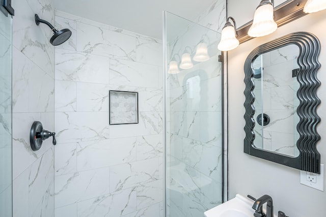 bathroom featuring tiled shower and sink