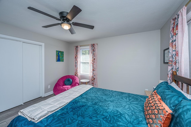 bedroom with ceiling fan, wood-type flooring, a closet, and a textured ceiling