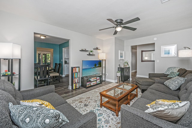 living room featuring dark wood-type flooring and ceiling fan