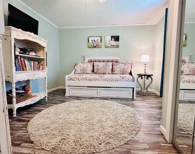 bedroom with dark wood-type flooring and crown molding