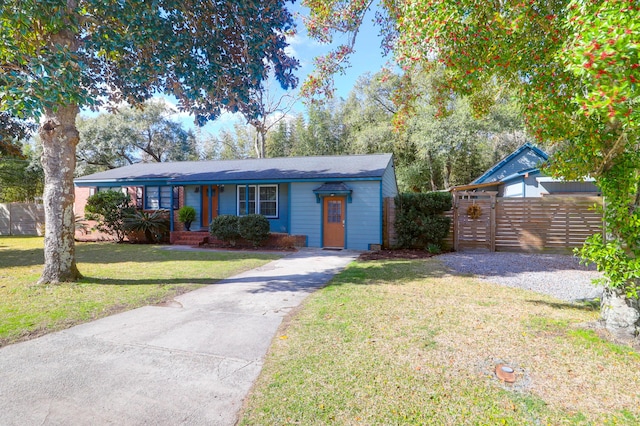 view of front of house with a front yard, fence, and driveway