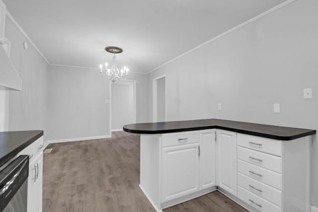 kitchen with stainless steel dishwasher, dark countertops, wood finished floors, white cabinetry, and crown molding