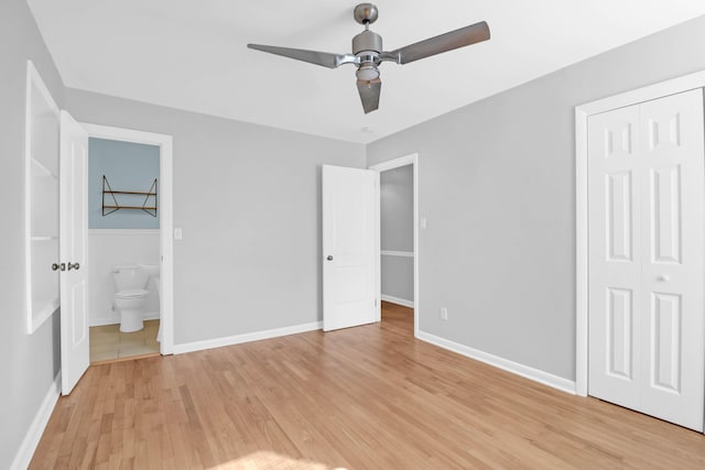 unfurnished bedroom featuring light wood finished floors, a closet, ensuite bath, and baseboards