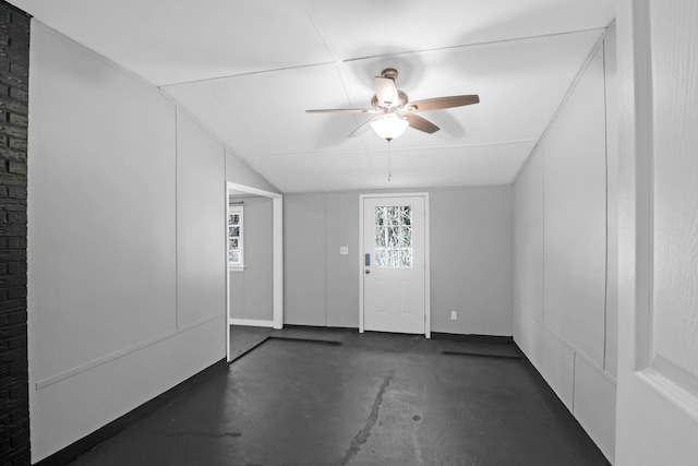 interior space with a ceiling fan, concrete flooring, and lofted ceiling