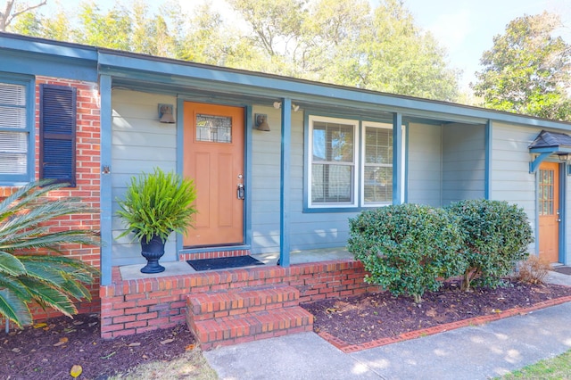 property entrance with brick siding and a porch