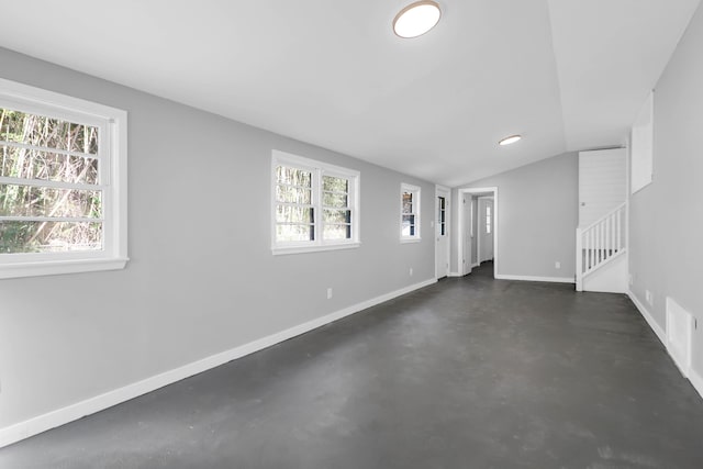 unfurnished room with stairway, baseboards, a healthy amount of sunlight, and finished concrete floors