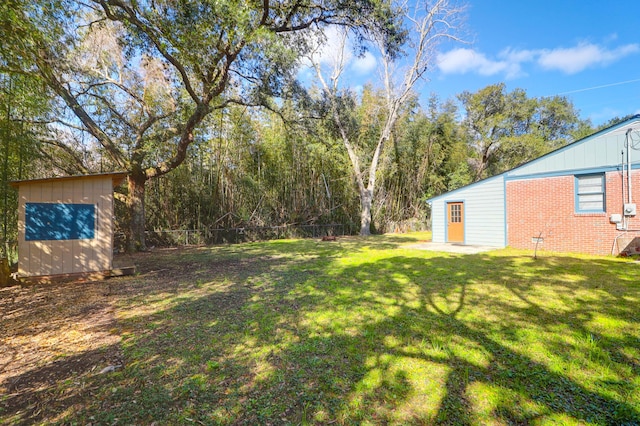 view of yard featuring an outbuilding, a storage unit, and fence