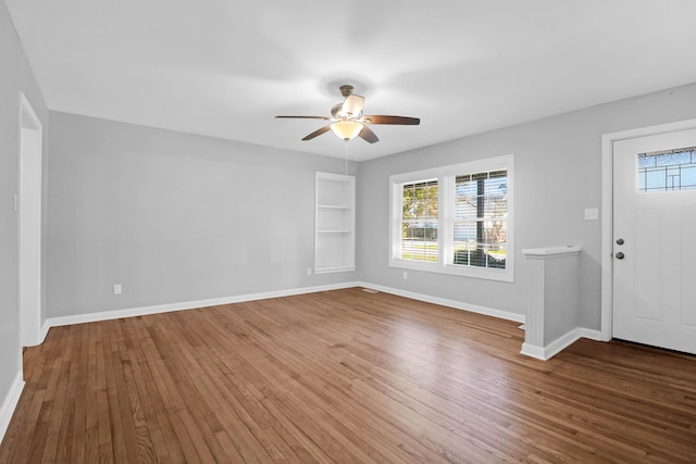 foyer with a healthy amount of sunlight, baseboards, and wood-type flooring