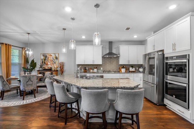 kitchen featuring a sink, wall chimney exhaust hood, dark wood-style floors, and stainless steel appliances