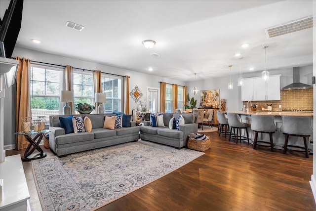 living room with recessed lighting, visible vents, and dark wood-style floors