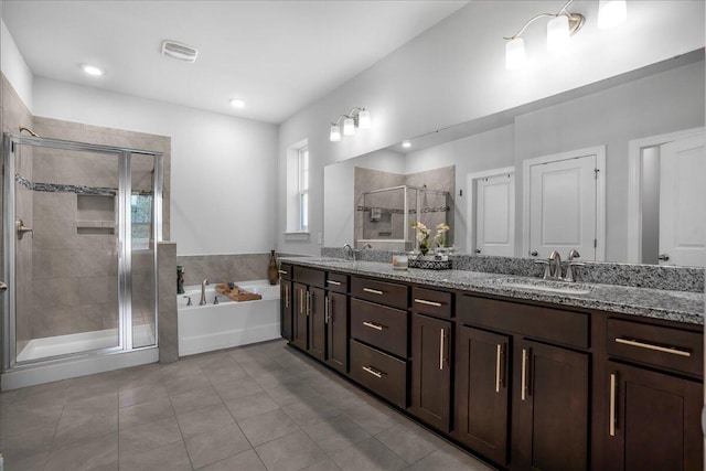 full bath with a shower stall, a garden tub, double vanity, and a sink