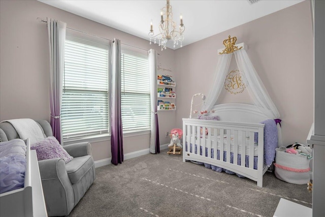 bedroom featuring a notable chandelier, multiple windows, a crib, and carpet flooring