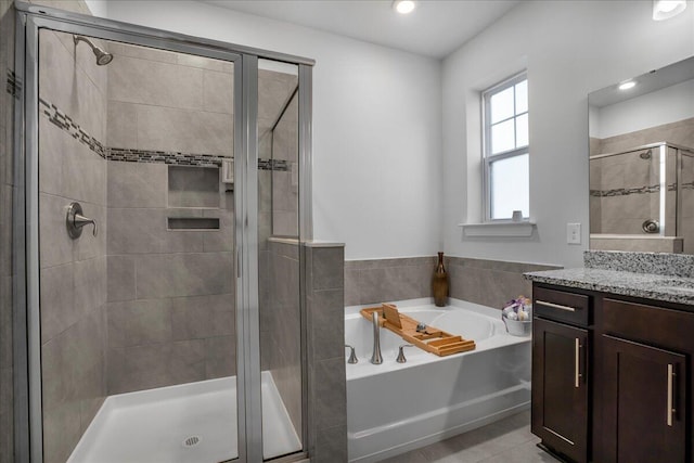 bathroom featuring vanity, a bath, and a stall shower