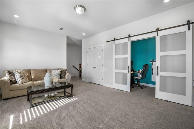 carpeted living room with a barn door, recessed lighting, baseboards, and visible vents