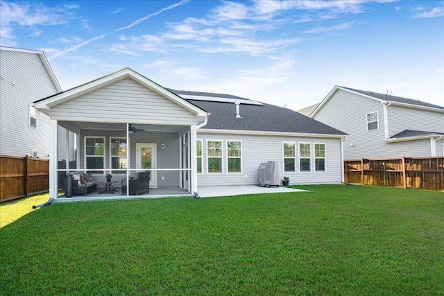 rear view of house featuring ceiling fan, a sunroom, a yard, a fenced backyard, and a patio area