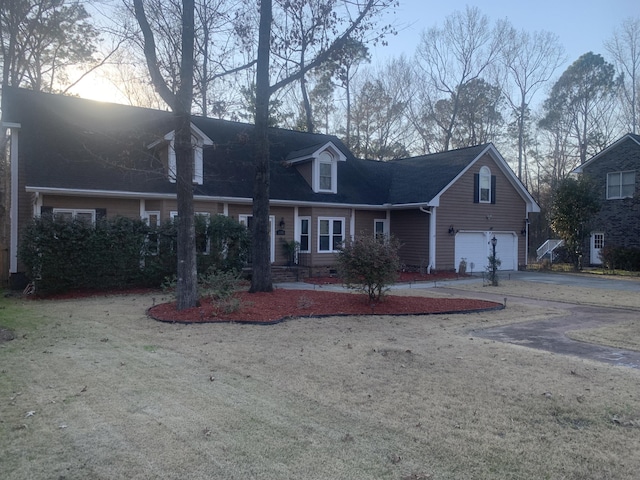 cape cod home with an attached garage and driveway