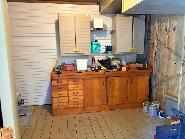 kitchen with light hardwood / wood-style floors and wooden walls