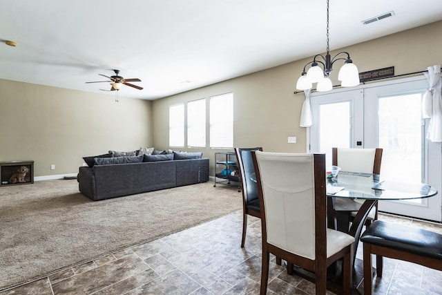 dining room featuring visible vents, carpet floors, baseboards, and ceiling fan with notable chandelier