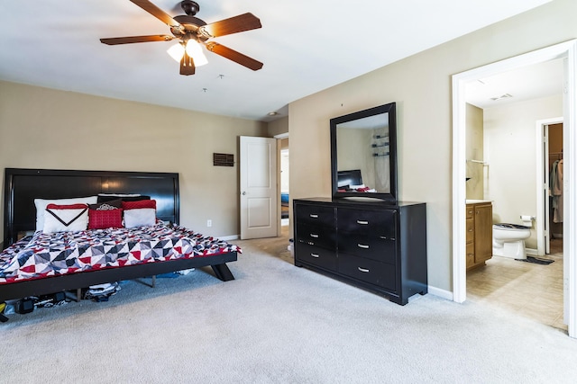 bedroom featuring ensuite bath, baseboards, and light carpet