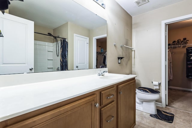 bathroom featuring tile patterned flooring, visible vents, a spacious closet, toilet, and vanity