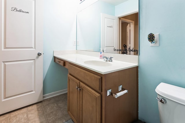 half bathroom featuring tile patterned flooring, toilet, and vanity