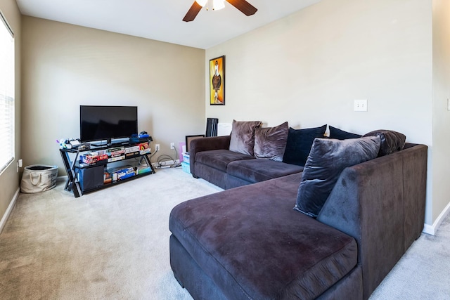 carpeted living room featuring baseboards and a ceiling fan