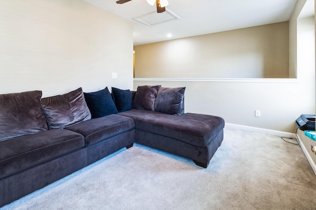 living area featuring attic access, a ceiling fan, baseboards, and carpet floors