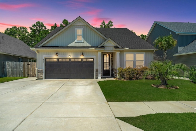 craftsman house with a lawn and a garage