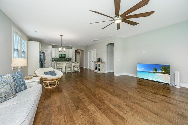 living room featuring hardwood / wood-style floors and ceiling fan with notable chandelier