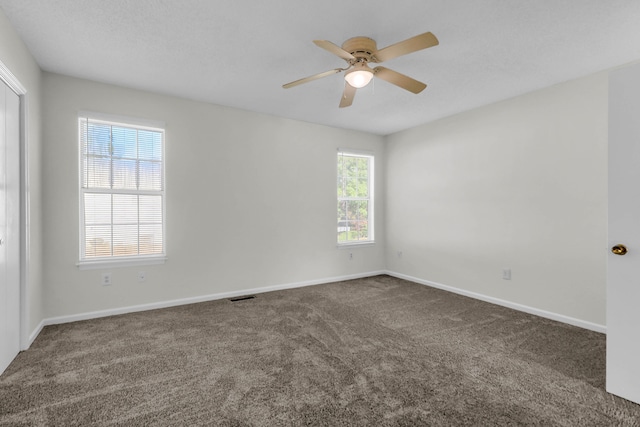 carpeted spare room featuring ceiling fan