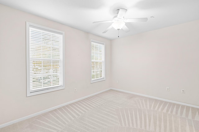 carpeted spare room featuring ceiling fan