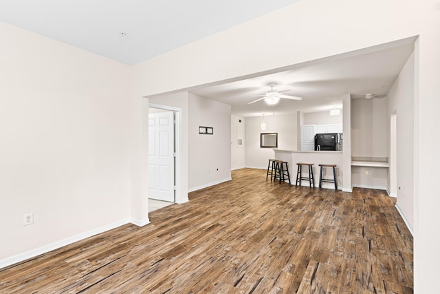 living room featuring ceiling fan and dark wood-type flooring