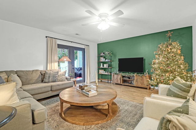 living room featuring hardwood / wood-style floors and ceiling fan