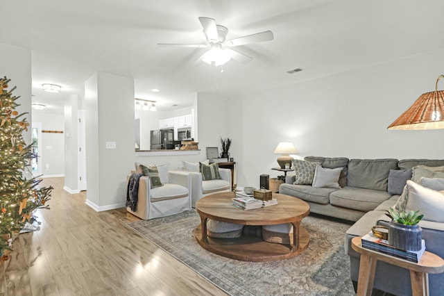 living room featuring ceiling fan and light wood-type flooring