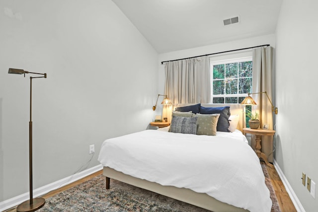 bedroom with hardwood / wood-style flooring and vaulted ceiling