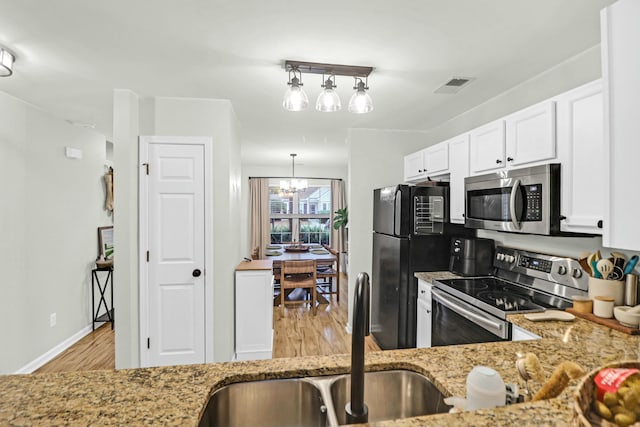 kitchen with sink, decorative light fixtures, a notable chandelier, white cabinetry, and stainless steel appliances