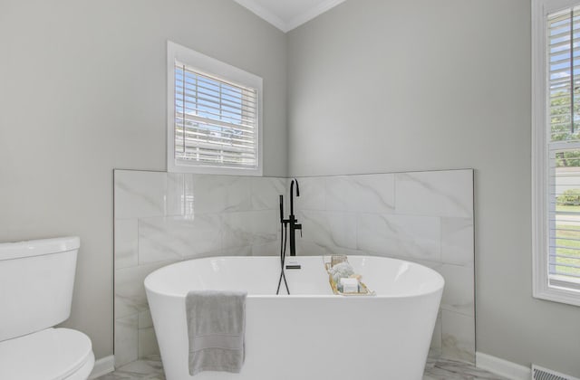full bath with toilet, tile walls, plenty of natural light, and marble finish floor