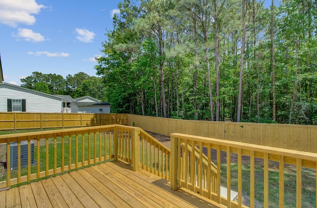 wooden terrace featuring a fenced backyard, central AC unit, and a yard