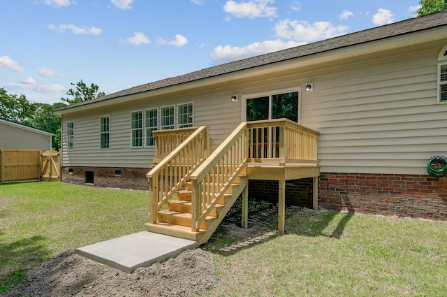 back of property with crawl space, a lawn, a wooden deck, stairway, and fence